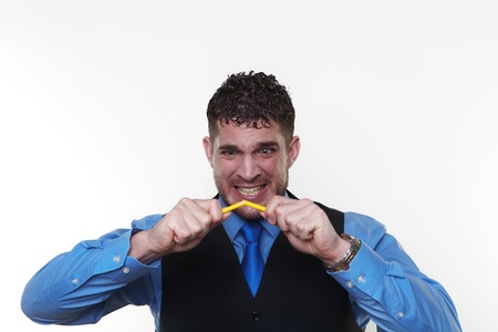 stressed out businessman breaking pencil in need of stress managementの写真素材