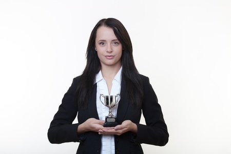 woman holding a small trophy in her handsの写真素材