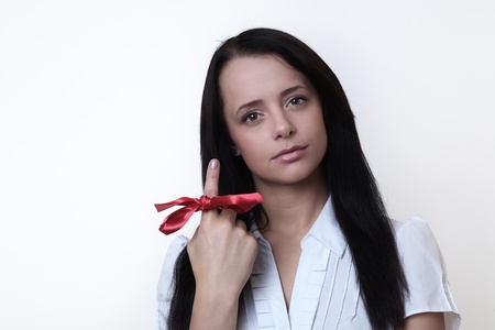 woman with a ribbon around her finger so she will not forget about something importantの写真素材