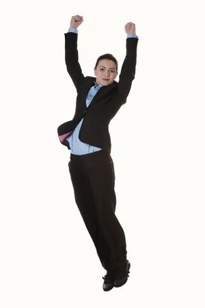 Jumping business woman. Celebrating successful businesswoman in suit jumping joyful  in full length.の写真素材