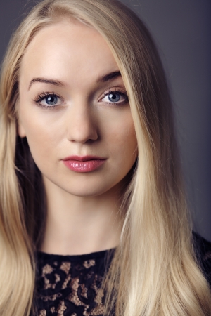 young woman close up portrait shot in the studio red lipstick and blonde hair looking at cameraの写真素材