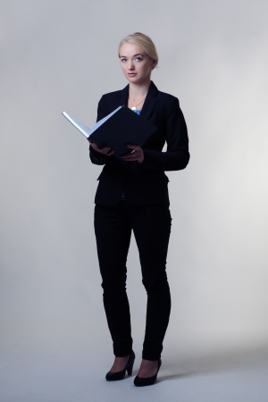 young business woman standing holding a large note book ready for workの写真素材