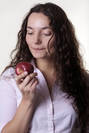 close up portrait of young woman about to eat a appleの写真素材