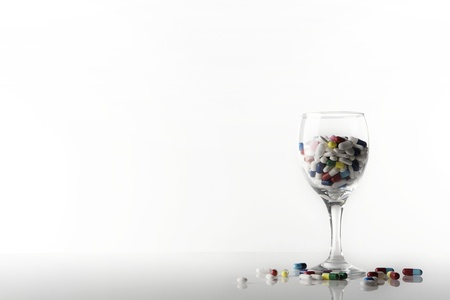 many pills in a wine glass, shot on a white backgroundの写真素材
