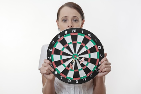 Businesswoman  looking over a dart board as if she is about to be shotの写真素材