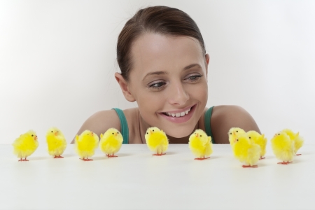 attractive women looking over a white table top at a group of model little easter chickens