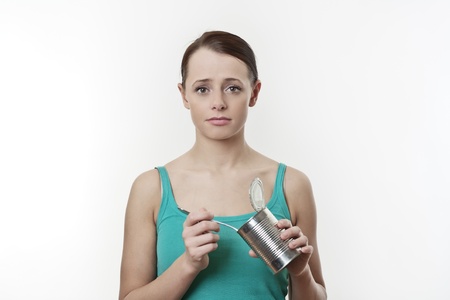 poor student  eating food from a tin no money for a healthy mealの写真素材