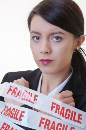 business woman wrapped up in fragile tapeの写真素材