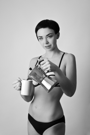 beautiful young woman making coffee in her underwearの写真素材