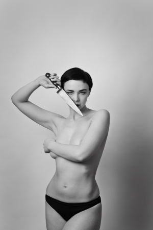 half naked woman holding a knifeの写真素材