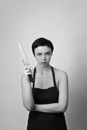 half naked woman holding a knife and just wearing a apronの写真素材