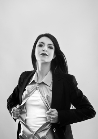 attractive businesswoman pulling her shirt apart doing a superhero businessman posesの写真素材