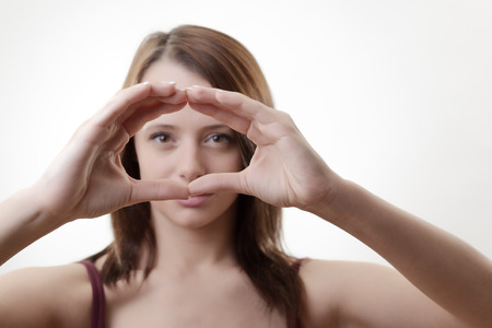 woman looking through hands in a large circleの写真素材