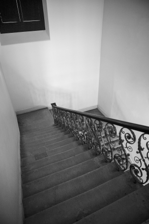 Indoor stone staircase with iron railingsの写真素材