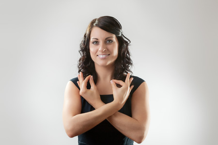 Portrait of an elegant businesswoman gesturing ok sign の写真素材