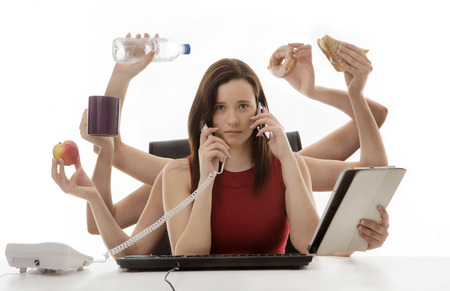 busy business woman multitasking in the office with eight armsの写真素材