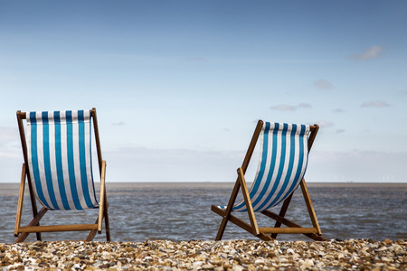 two deck chairs by them self looking out towards the seaの写真素材
