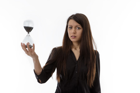 woman holding up a hour glass sand timer watching time slip away