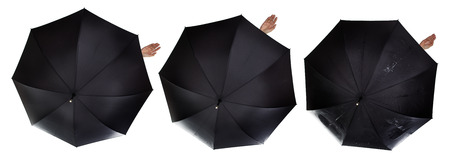 business umbrella with a single female hand poking out from the safety of the umbrella to see if it's rainingの写真素材
