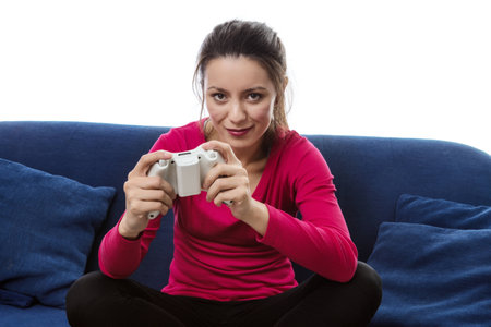 woman sitting on a sofa playing a game on a games consoles controller