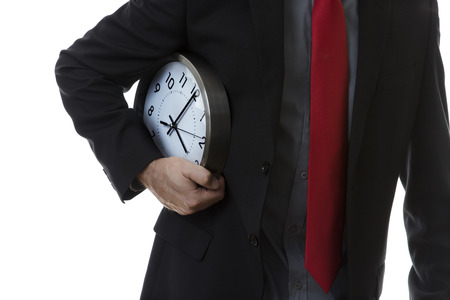 Businessman with a clock under his arm as if he is running with it.の写真素材