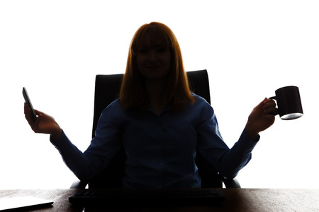 silhouette of business woman sitting at her deskの写真素材