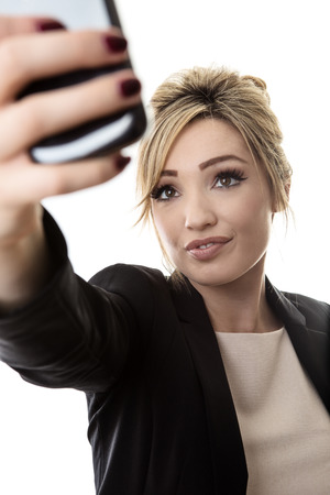 business woman taking a selfie to send to her friendsの写真素材