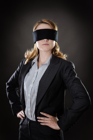 portrait of a business woman blind folded shot in the studio on gray backgroundの写真素材