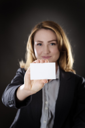 business woman holding up and showing you a blank white cardの写真素材