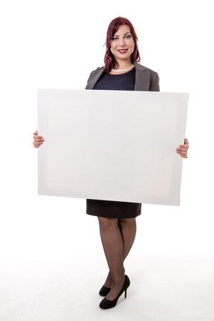 Studio shot of a woman in a business suit holding a blank card to display a messageの写真素材