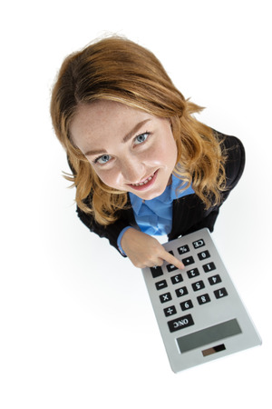 Woman in a business suit using a giant calculator to help her work the problem outの写真素材