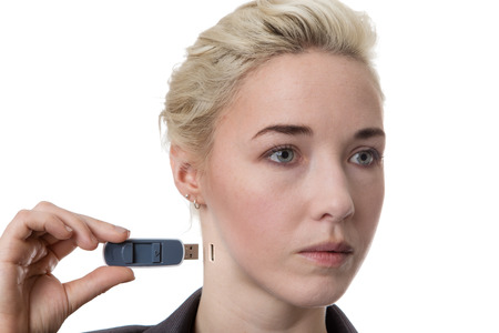Woman in a business suit holding a memory stick putting it into her neck