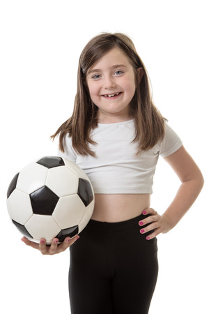 Pretty young girl posing with a football in her right handの写真素材