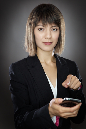business woman texting on a mobile phone shot in the studio onm a gray backgroundの写真素材