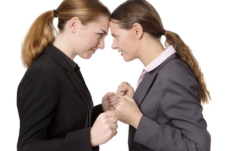 shot of two businesswomen knocking their heads together.  isolated on whiteの写真素材