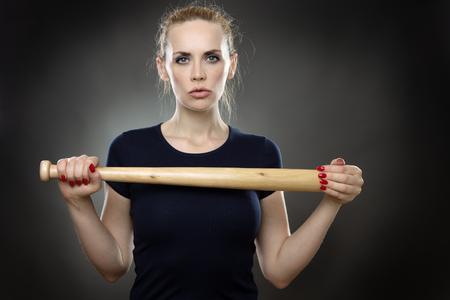 Studio shot of a business woman with a baseball bat.の写真素材