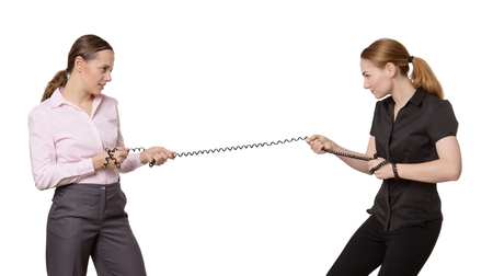 office business workers pulling on a telephone wire in a tug of war.  Isolated on whiteの写真素材