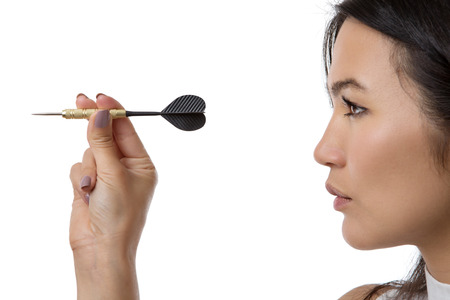 side profile close up shot of woman throwing a dart and taking aimの写真素材