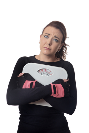unhappy looking woman holding scalesの写真素材