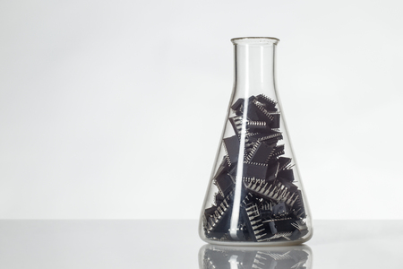 Conical flask holding computer chips inside shot in the studio on white background