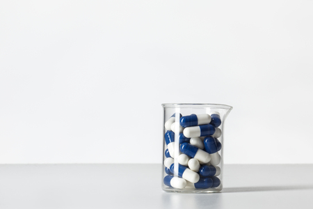 beaker flask with pills inside, shot in the studio on white backgroundの写真素材