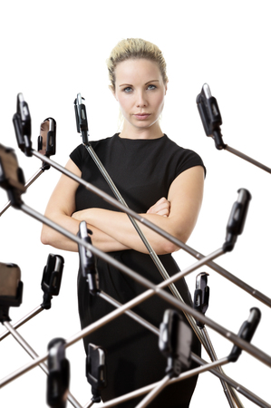 woman surrounded by phones on selfie stickの写真素材