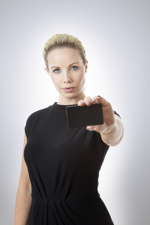 Business woman holding up a business cardの写真素材