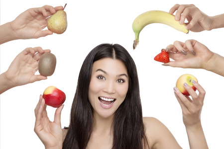 woman holding fruit and veg, shot in the studio on a white backgroundの写真素材