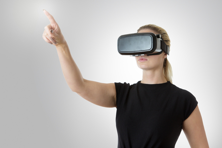 wearable technology of a virtual reality business woman of the modern world pointing with her fingerの写真素材