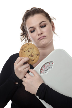 fitness woman not sure if she should eat a chocolate chip cookieの写真素材
