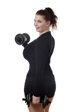 woman working out with dumbbells looking round at camera from behindの写真素材