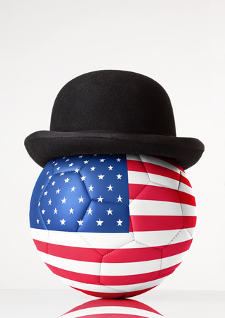 still life image of football wearing a bowler hat with USA flag superimposed on footballの写真素材