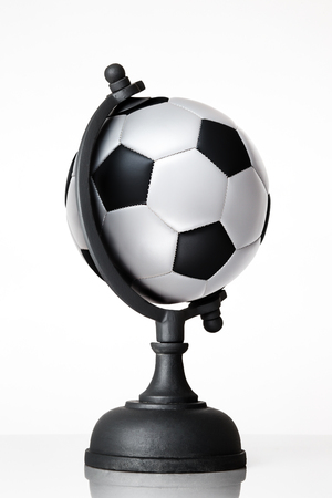 still life image of football world globe on whiteの写真素材