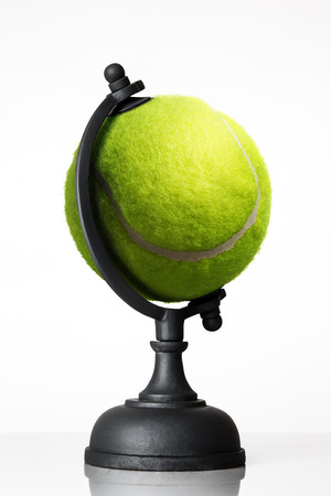 still life image of tennis ball world globe on whiteの写真素材